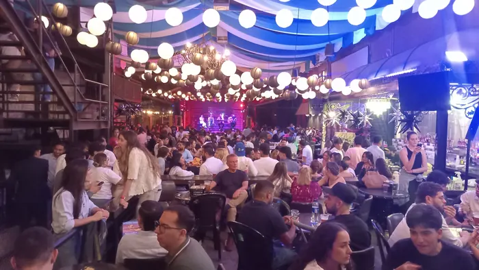 Guests gathered around tables during a busy event at Red Macaw
