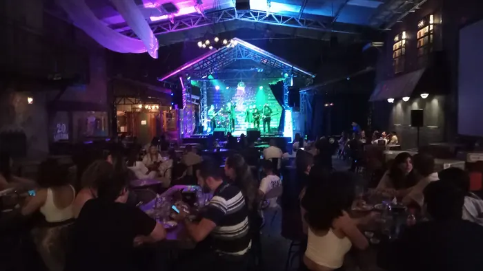 A band performing beneath colorful stage lighting at Red Macaw